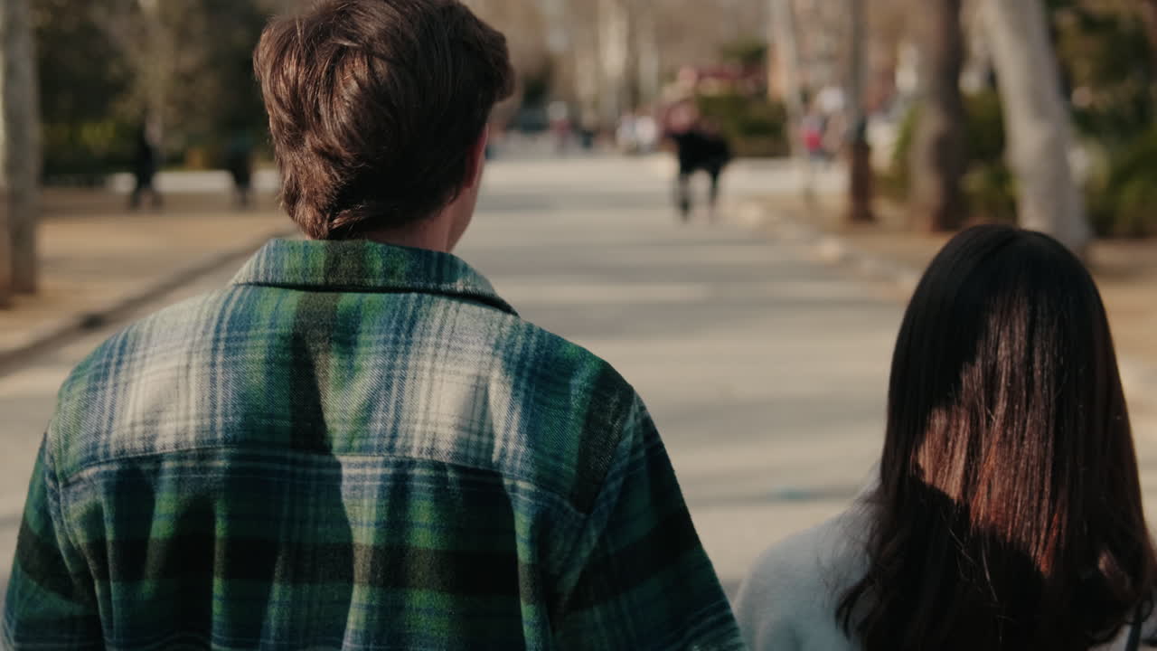 Young romantic young pair meet on the street, hug, back view