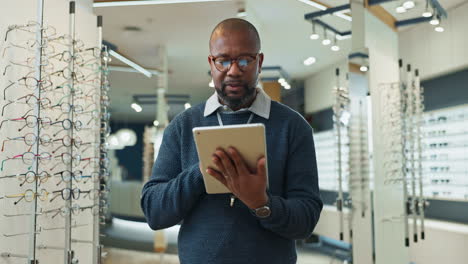 optician using a tablet in eyeglasses store