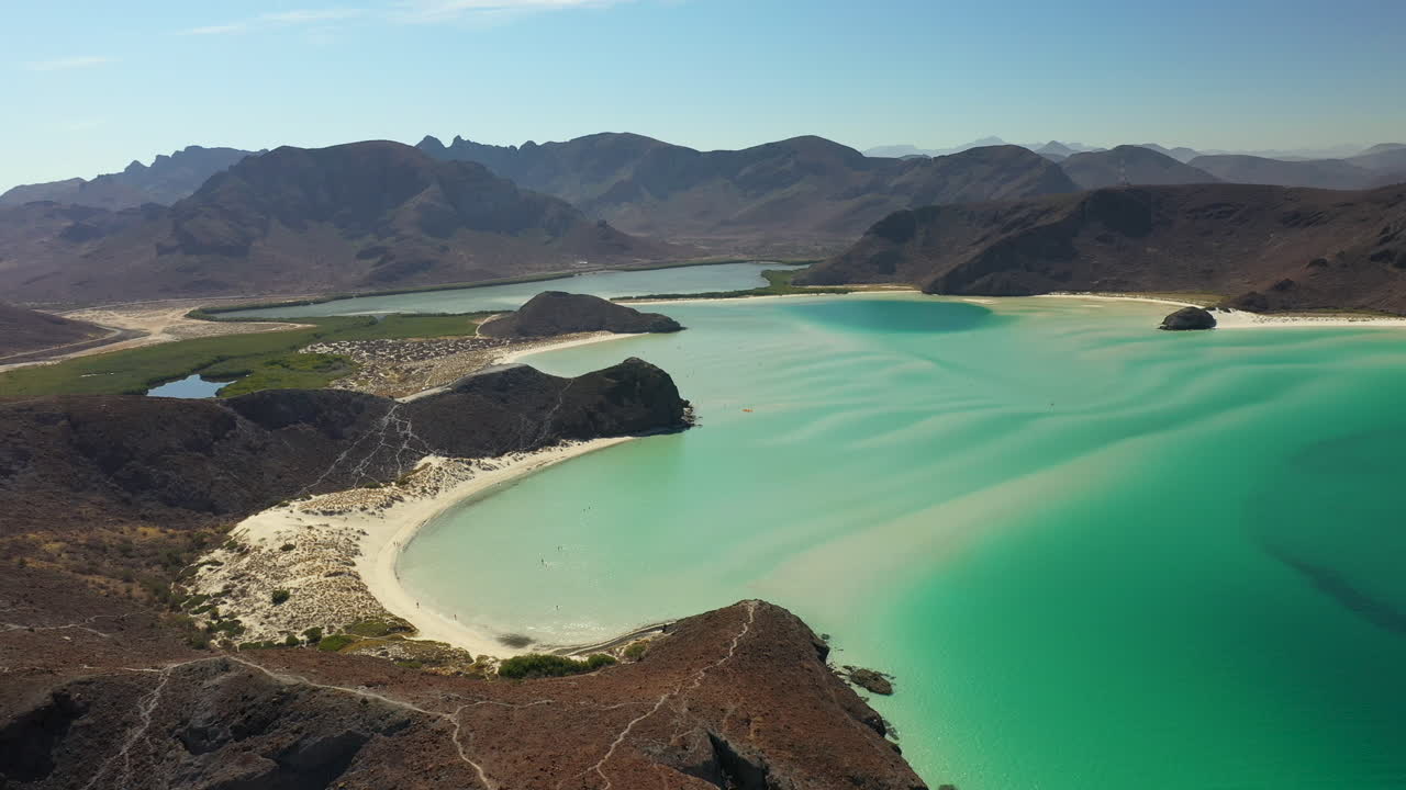 balandra 해변, 붉은 언덕, 청록색 바다, 백사장 해변 및 산의 전망을 영화처럼 넓게 회전하는 드론 샷