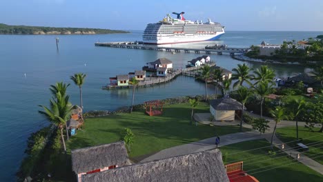 people walking in the resort with cruise ship docked in the aber cove cruise terminal in dominican republic