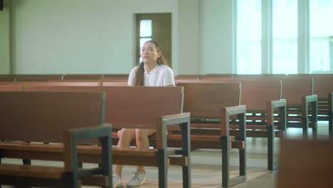 portrait of a youthful woman enters church and sit