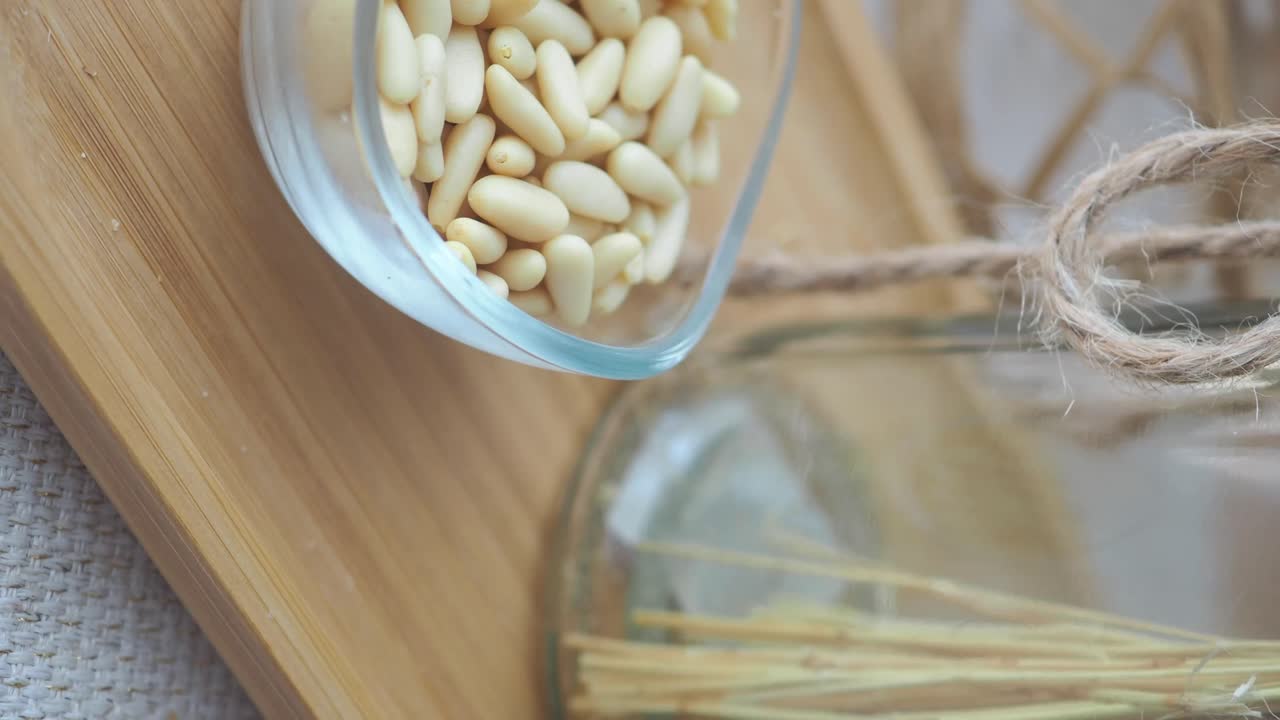 Pine Nuts in a Glass Bowl on a Wooden Tray