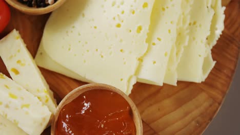 different types of cheese, tomatoes and bowl of jam and spices