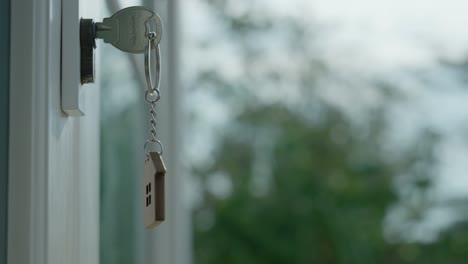 sell your house, rent house and buy ideas. the house key for unlocking a new house is plugged into the door.