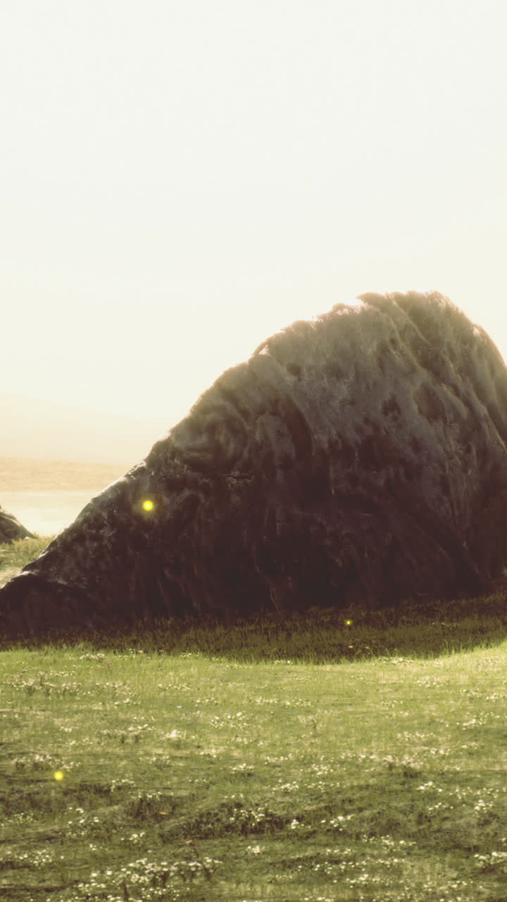 Serene landscape featuring a majestic rock formation under golden sunlight