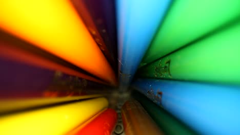 moving into a jar of colored pencils where they are being displaced as the lens pushes to the bottom of the jar