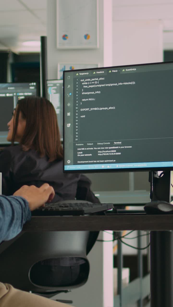 Vertical video: Asian system engineer working with html script on computer screen