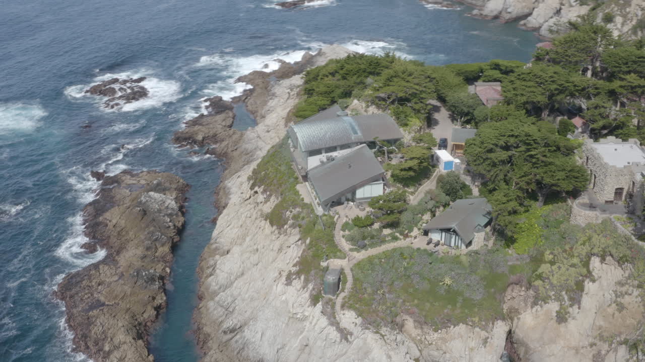 4K aerial of cliffside mansion with the surrounding neighborhood of the Carmel Highlands in California.