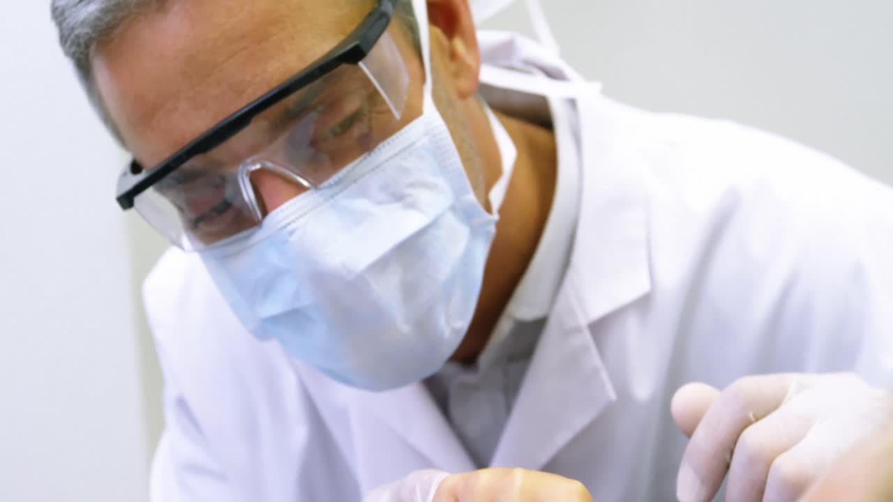 Dentista che spazzola i denti di un giovane paziente