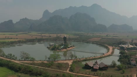 Aerial-of-Kyauk-Ka-Lat-Pagoda,-limestone-rock-formation-with-lake