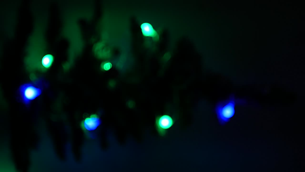 크리스마스 트리의 흐릿한 실루과 반이는 불명확한 불빛이 초점을 맞추지 않는 수직 4k 비디오 xmas 새해 인테리어와 다채로운 불빛 배경, 원 반이는 반이는 보케 효과.