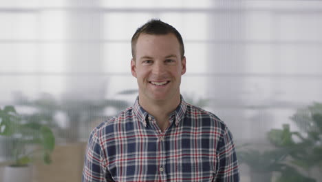 portrait-of-positive-young-businessman-entrepreneur-smiling-happy-looking-at-camera-confident-caucasian-male-in-workplace