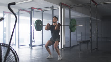 lifting barbell, man working out in gym, focusing on strength training