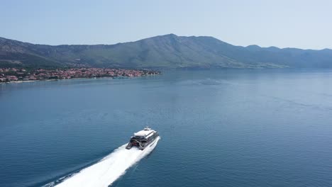 Vista-Aérea-Del-Catamarán-Con-Retrolavado-En-Aguas-Azules-Del-Mar-Adriático-Cerca-De-La-Ciudad-De-Korcula-En-Croacia