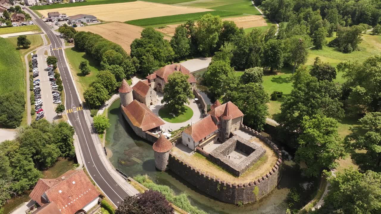 Drone pushes over to Hallwyl moated castle on lake Hallwil, calm water, rich greenery and historic architecture
