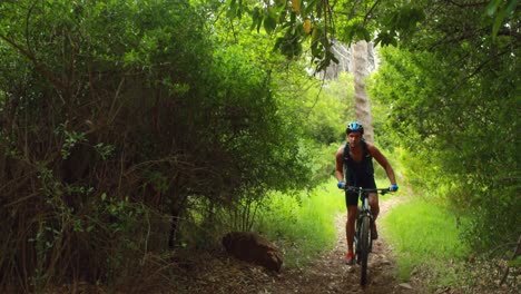 Man-biking-through-a-forest-