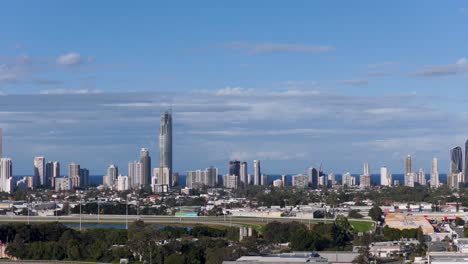 aerial footage captures the gold coast skyline under clear blue skies, highlighting modern skyscrapers and coastal scenery in daylight