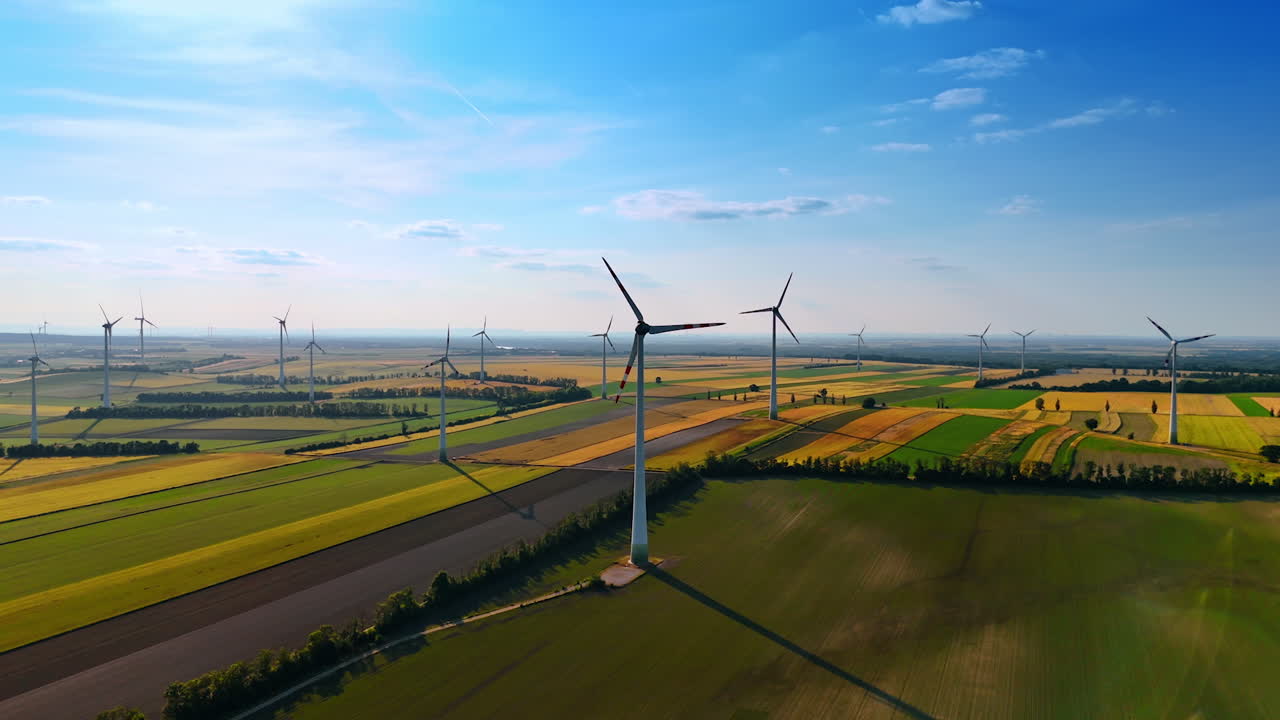 Wind farm in the agricultural fields. Production of green energy with the power of wind. Aerial view.