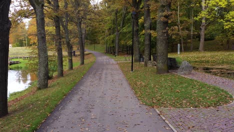 Calm-park-pathway-with-autumn-colors,-dolly-forward-view