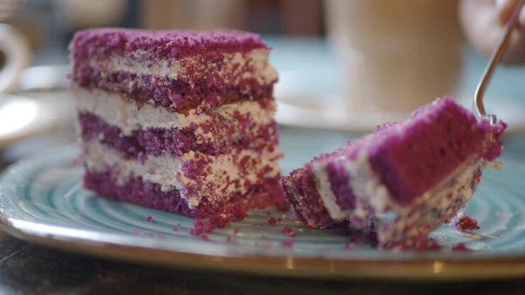 Fetta di torta viola su un piatto blu