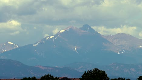 el pico de una montaña rocosa distante resiste mientras las nubes se agitan en este lapso de tiempo