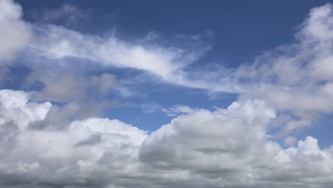 Fluffy-clouds-moving-away-from-camera-on-bright-sunny-summer-day