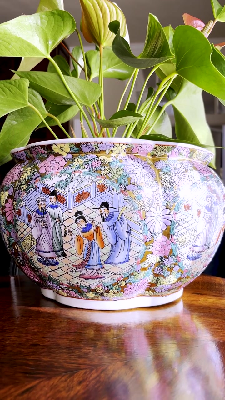 Vertical. Slider up to decorative ceramic pot plant with Asian cultural scene