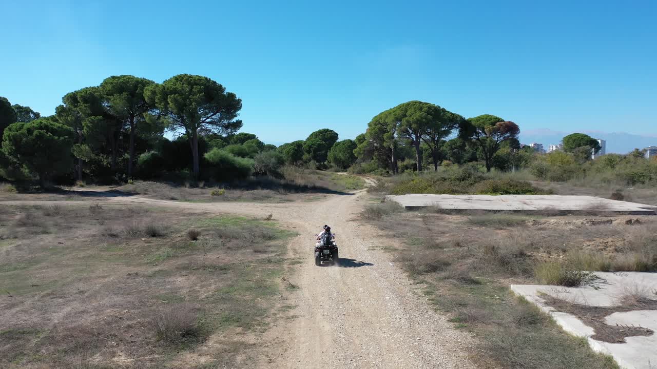 vista aérea de una pareja conduciendo un vehículo atv en un suelo polvoriento sobre antalya, turquía