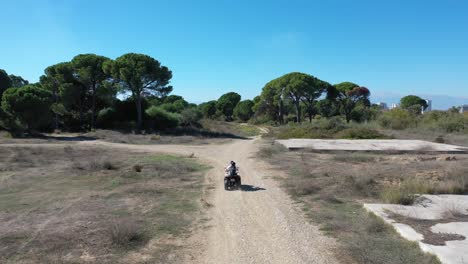 Aerial-View-of-Couple-Driving-ATV-Vehicle-on-Dusty-Ground-Above-Antalya,-Turkey