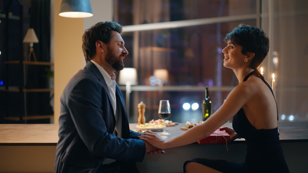 Primo piano di un gentiluomo che regala qualcosa alla moglie a casa, durante una serata romantica. Coppia innamorata.