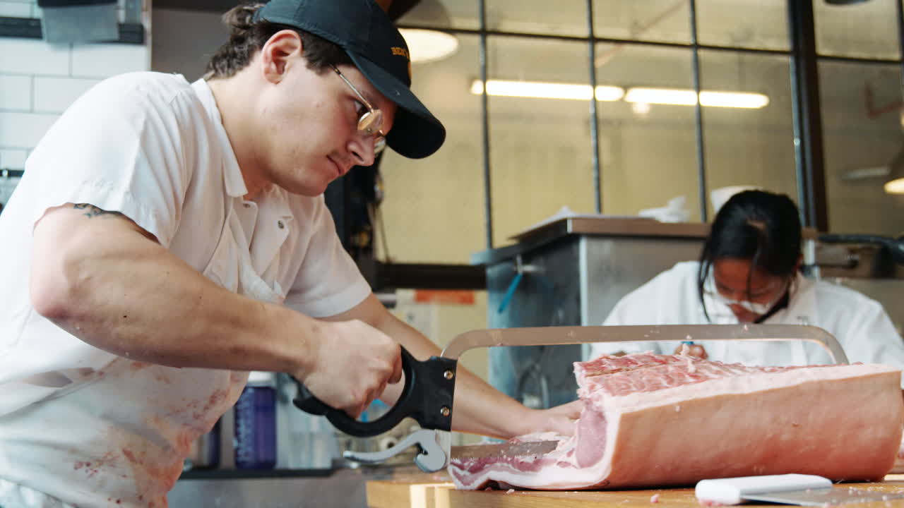 Two butchers preparing meat to sell at a butcher's shop