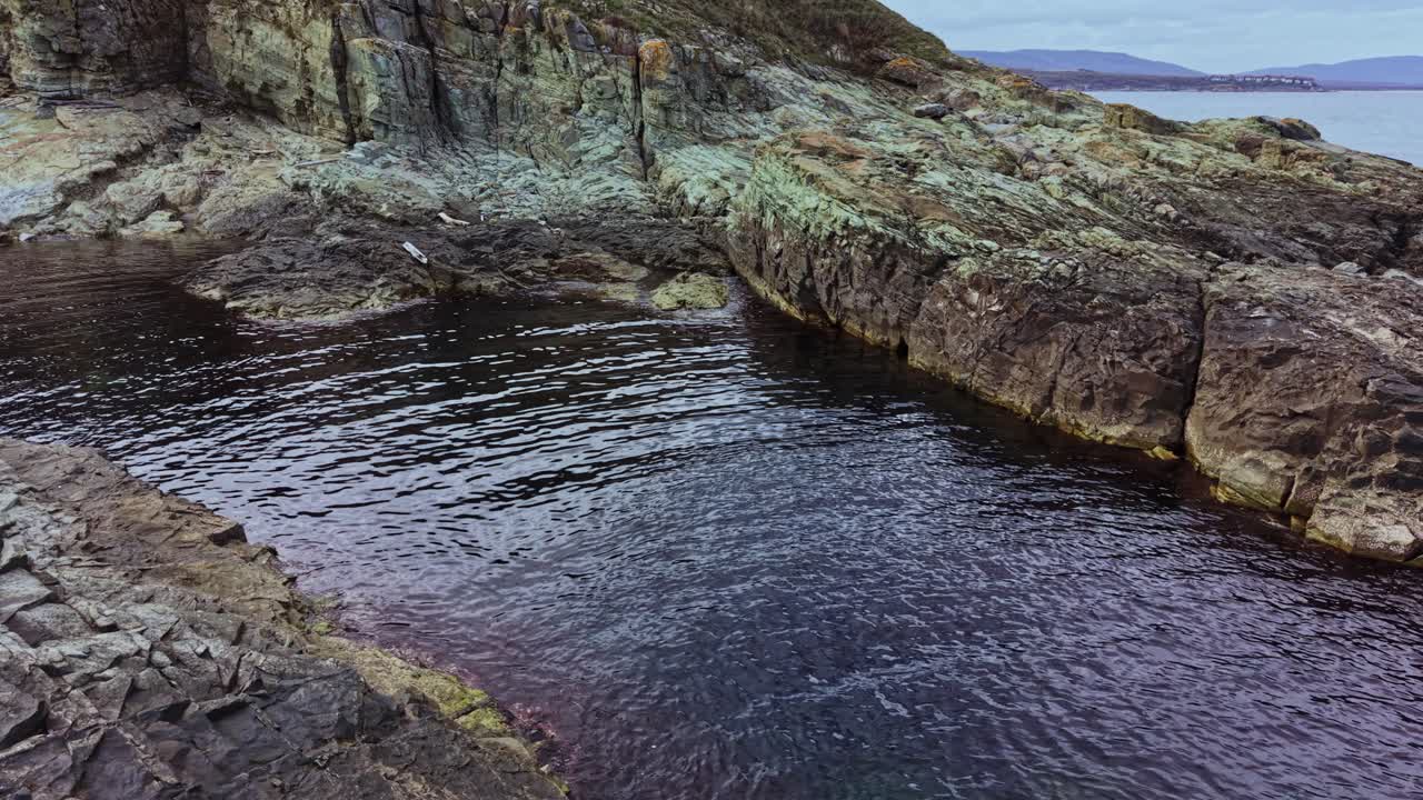 Rocky coastline with calm water captured from above during daylight