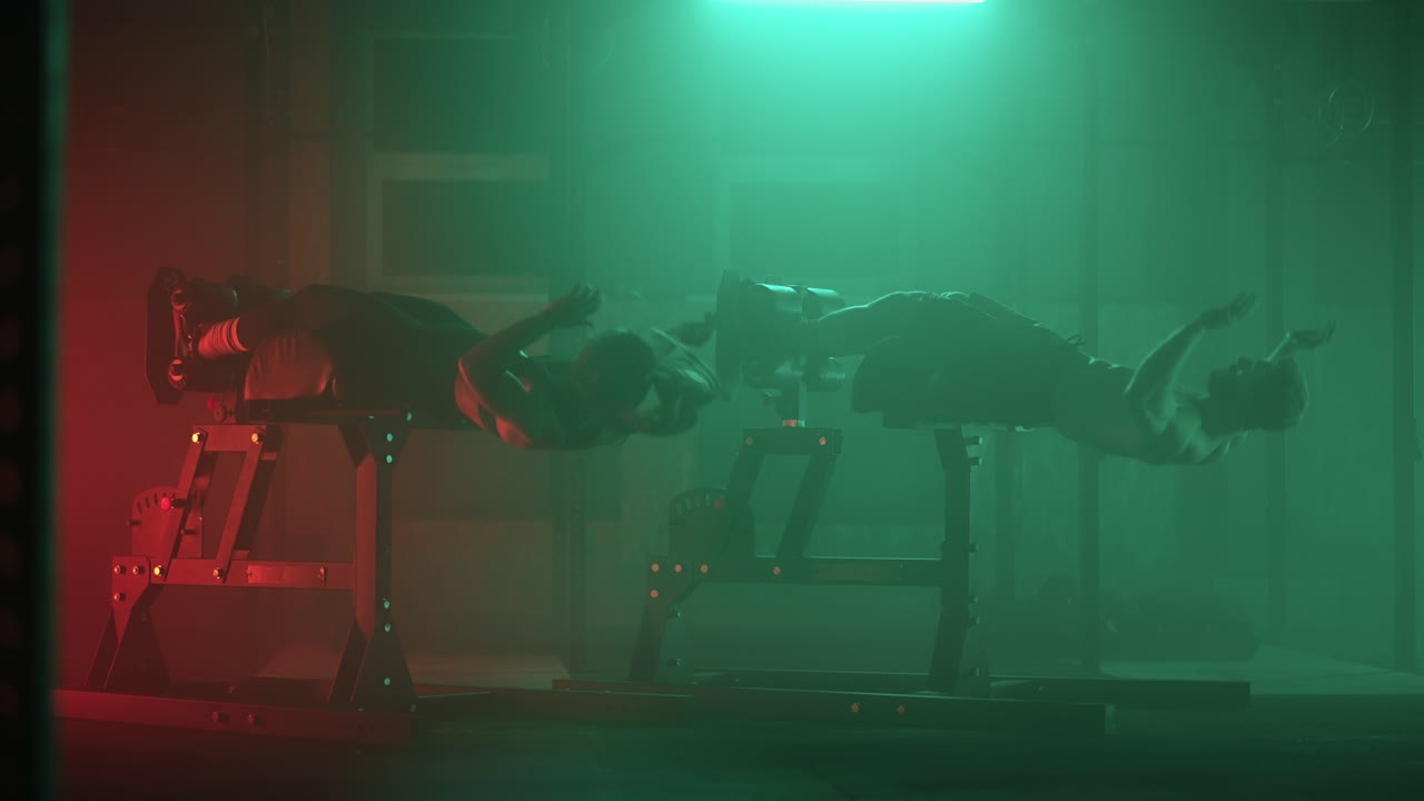 un hombre y una mujer hacen ejercicios abdominales haciendo levantamientos de cuerpo juntos en el gimnasio. dos personas hacen un ejercicio de vientre juntos