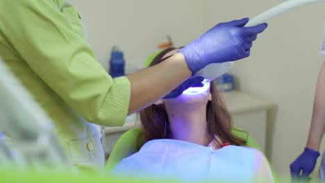 teeth whitening with ultraviolet lamp. patient at bleaching teeth procedure