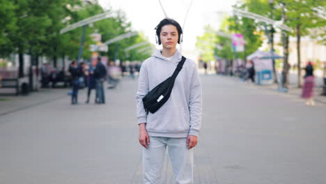 teenager with headphones and bag on a city street