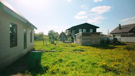 Footage-of-various-summer-houses-during-spring,-surrounded-by-yellow-flowers,-green-grass,-and-bathed-in-sunlight