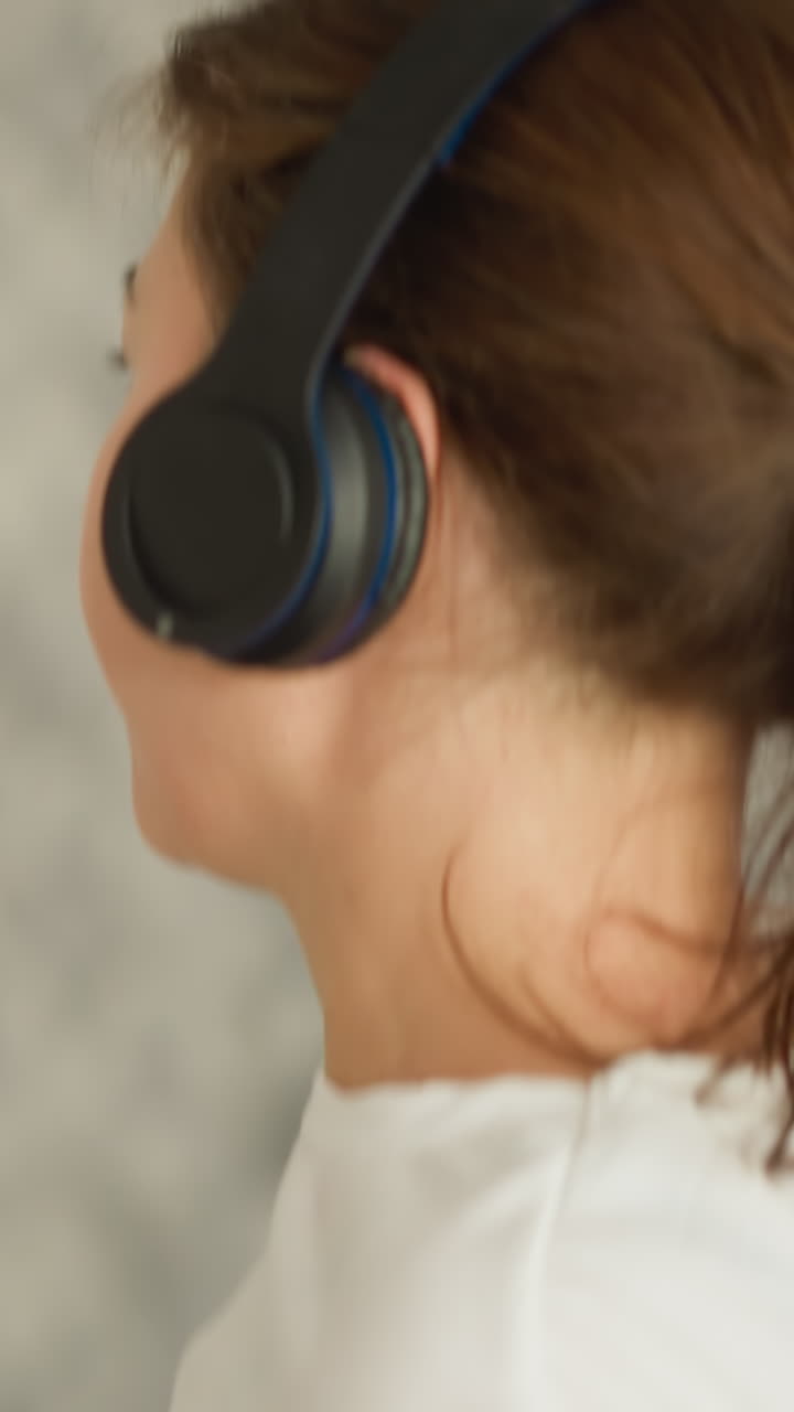 atleta femenina con auriculares corriendo en el interior de primer plano. mujer con auriculas inalámbricas se entrena en una cinta de correr en la habitación contra el televisor. entusiasta de los deportes