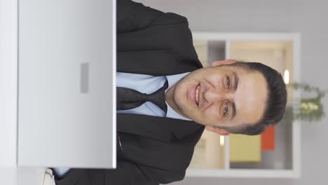 Vertical-video-of-Home-office-worker-man-smiles-at-camera.