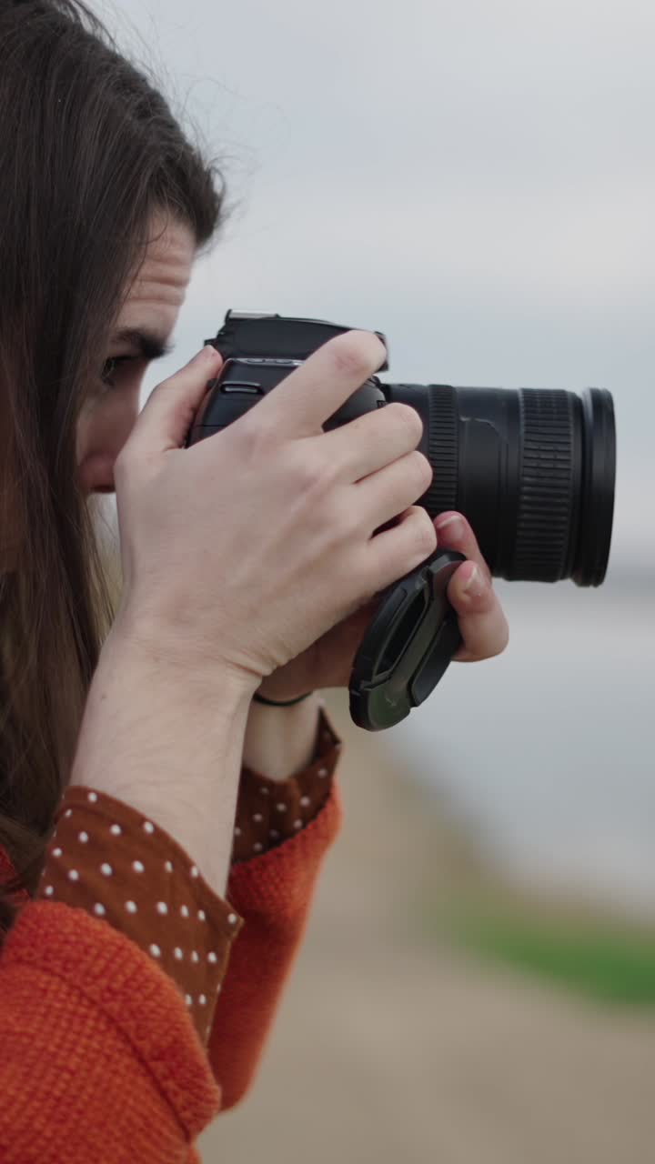 Donna che scatta foto all'aperto vicino al lago