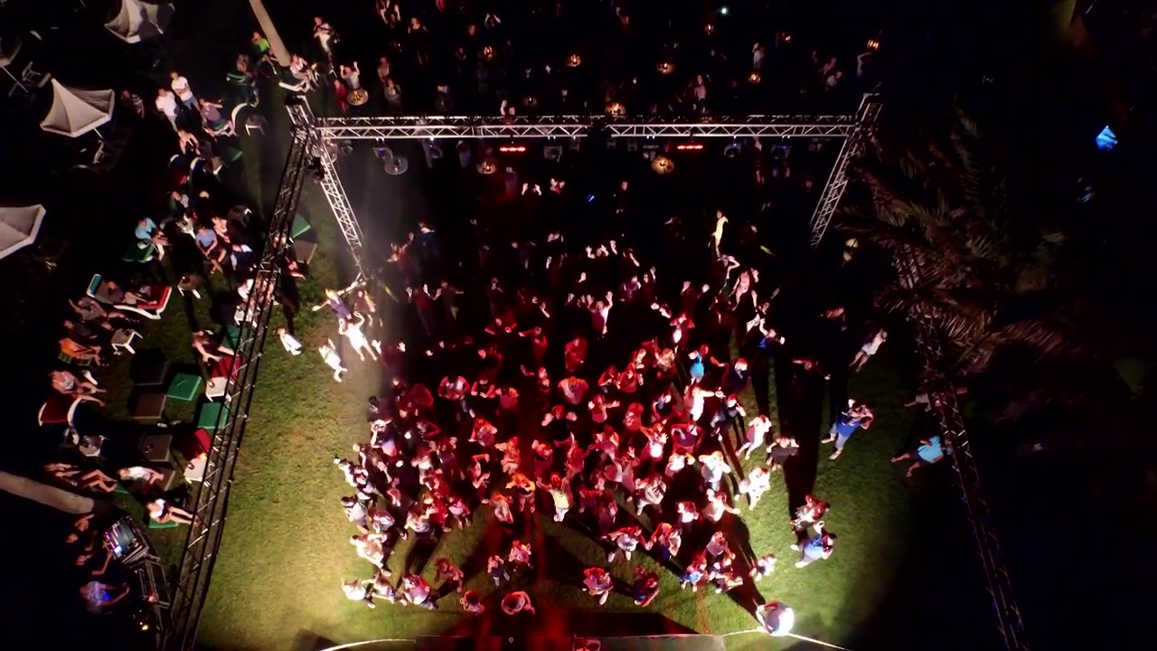 Luchtfoto van mensen die dansen op een buitenfeest 's nachts.
