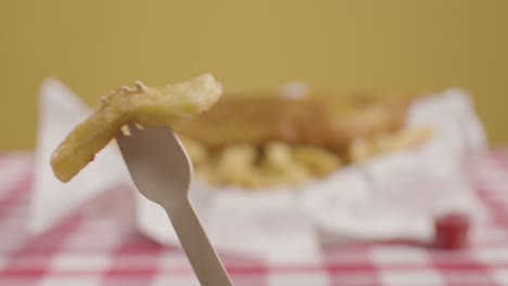 person eating traditional british takeaway meal of fish and chips