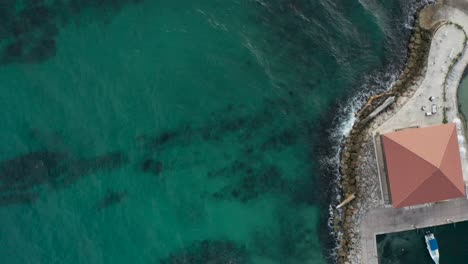 aerial drone shot, towards the outskirts of the wave breaker and the lighthouse
