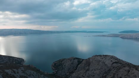 Aerial-panning-shot-of-rocky-seashore-and-islands-in-cloudy-day