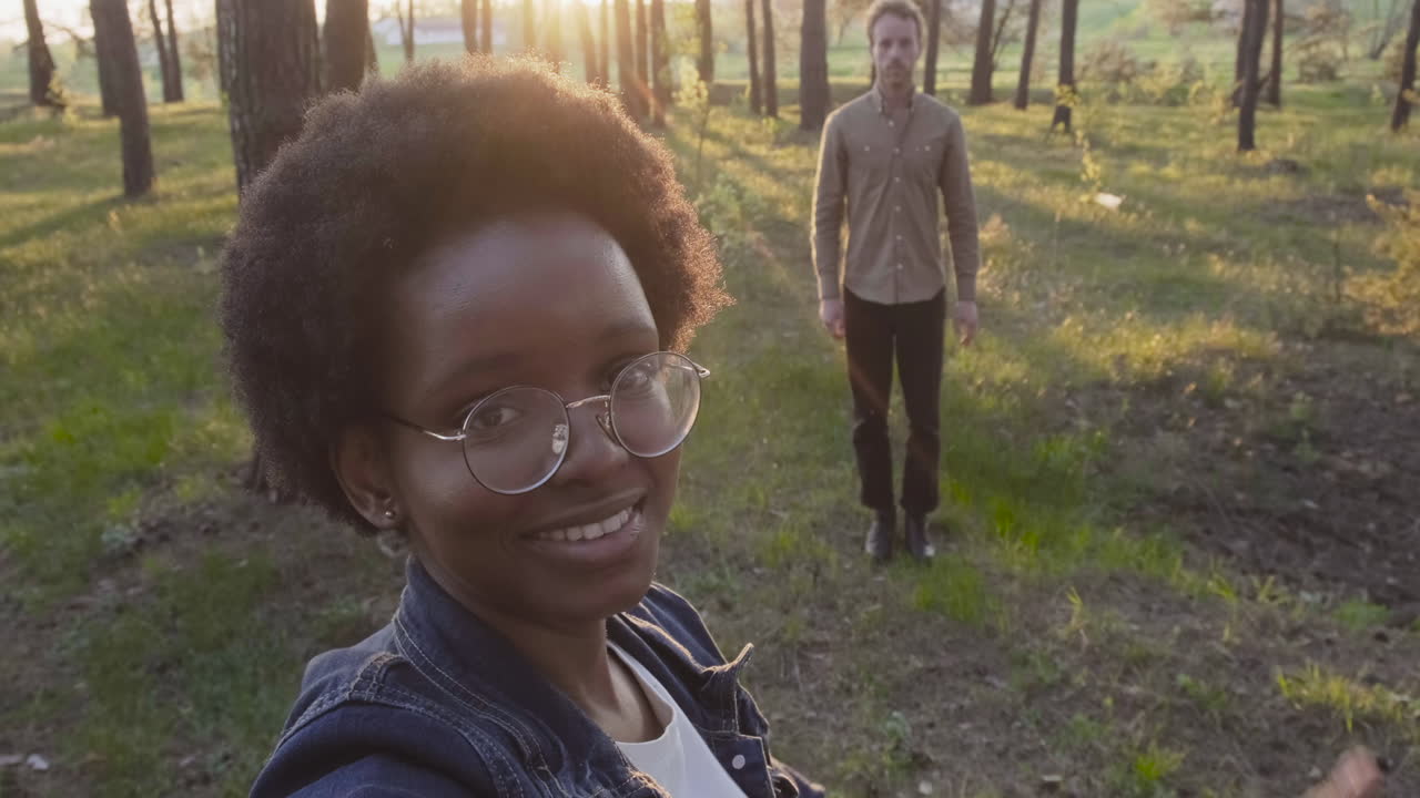 A Young Girls Takes A Selfie Of Her And A Friend In The Forest And Say Hello