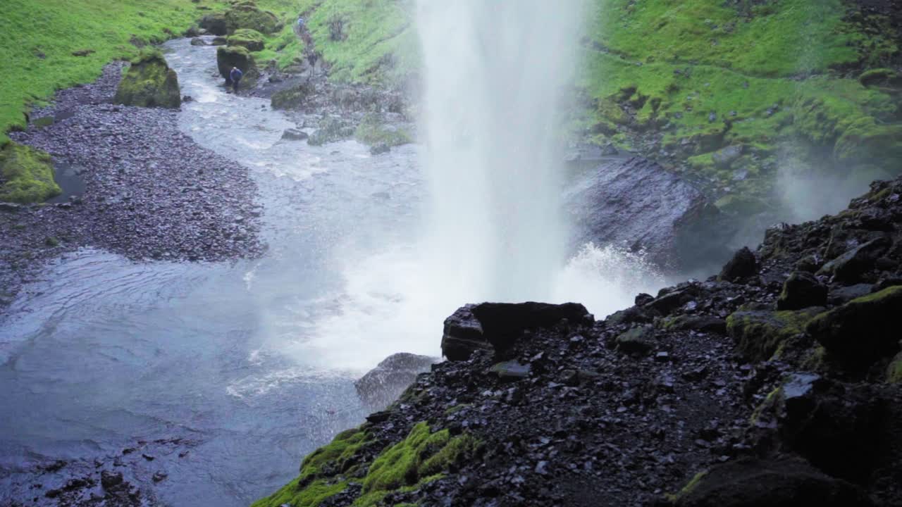 la base de una cascada mientras se estrella contra las rocas en islandia - cámara lenta