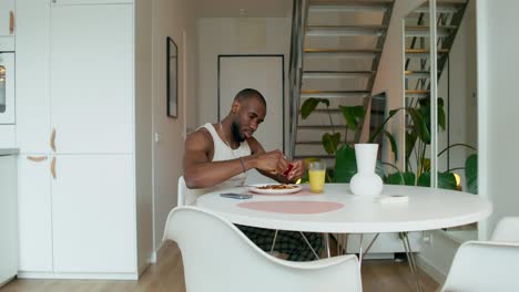 hombre comiendo desayuno en una cocina moderna