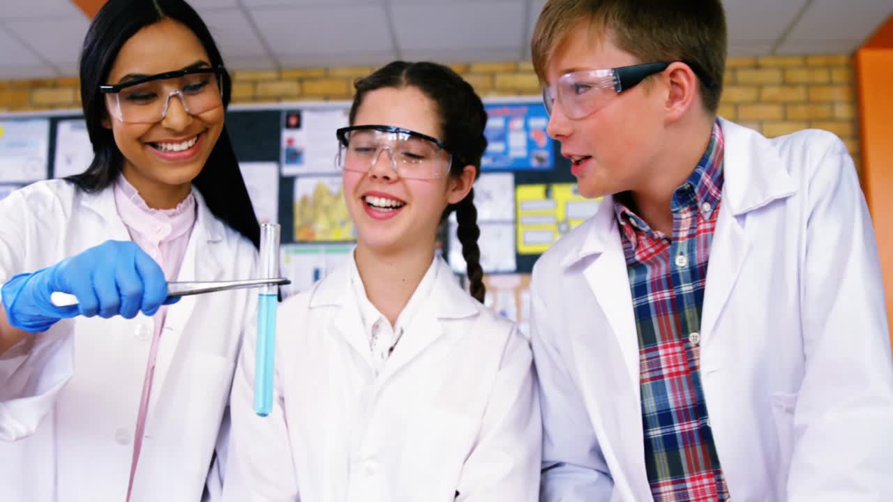 niños de la escuela sonriendo haciendo un experimento químico en el laboratorio