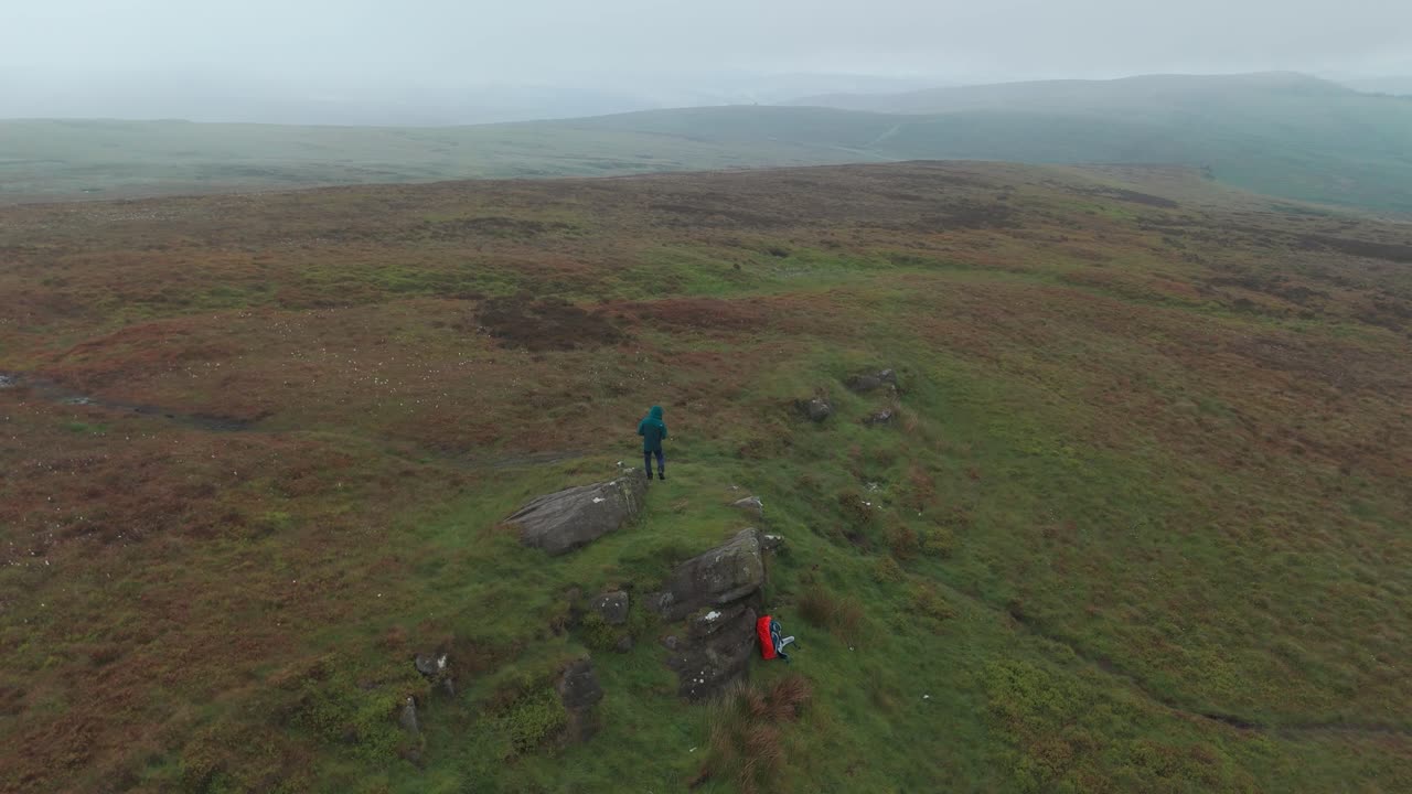 turista explorando el distrito peak cinco piedras en un día nublado en inglaterra