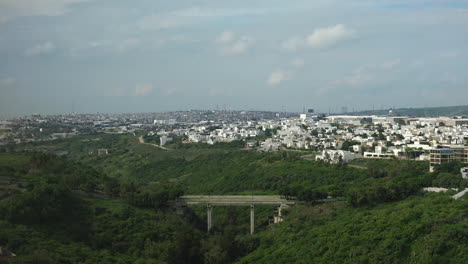 time lapse of leon, guanajuato, mexico with a blue sky, green forest and a small bridge