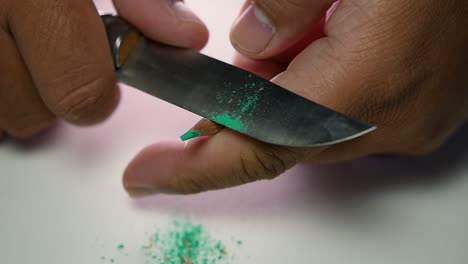 Footage-of-hands-slowly-sharpening-a-pencil-and-some-coloured-pencils-with-a-sharp-knife